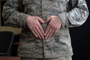 Soldier holding his stomach with his hands.