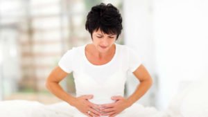 ibs, woman bent over in pain