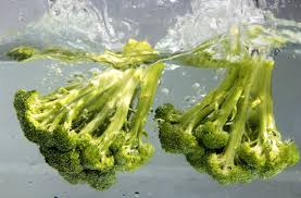 Broccoli splashing in clear water.