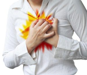 woman holding chest because her acid refluxes is flaring up