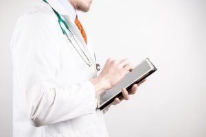 Doctor with a tablet speaking to a patient.