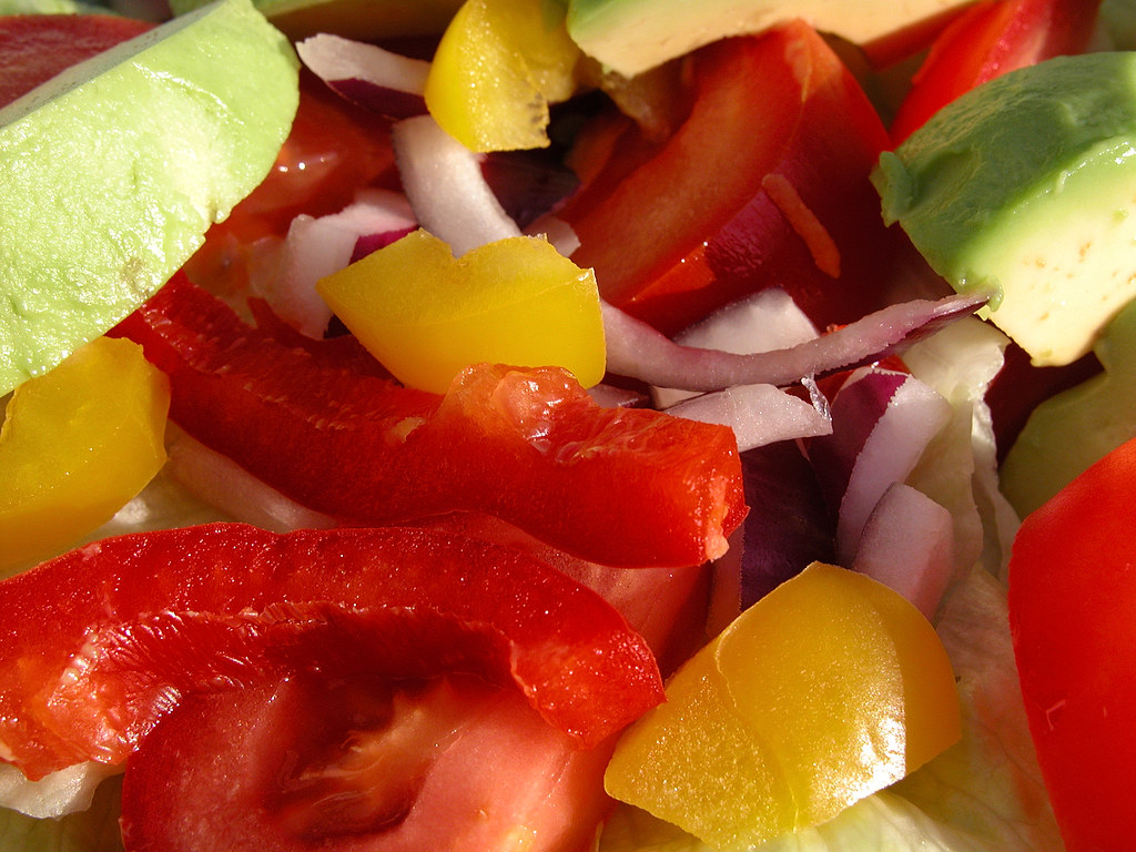 Ensalada colorida compuesta de pimientos, aguacate y tomates.