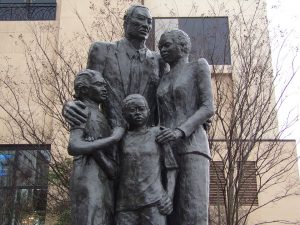 Statue of a family holding each other closely.